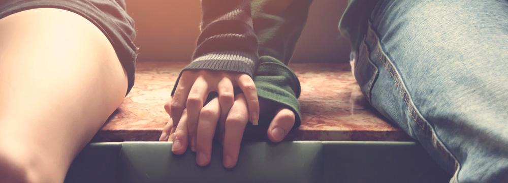 Two individual's hands resting on each other